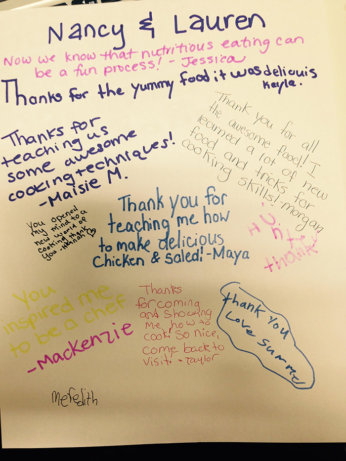 Close-up of written comments from girls who participated in the S.H.E. cooking class, such as 'I learned a lot of new food and tricks for cooking skills!'