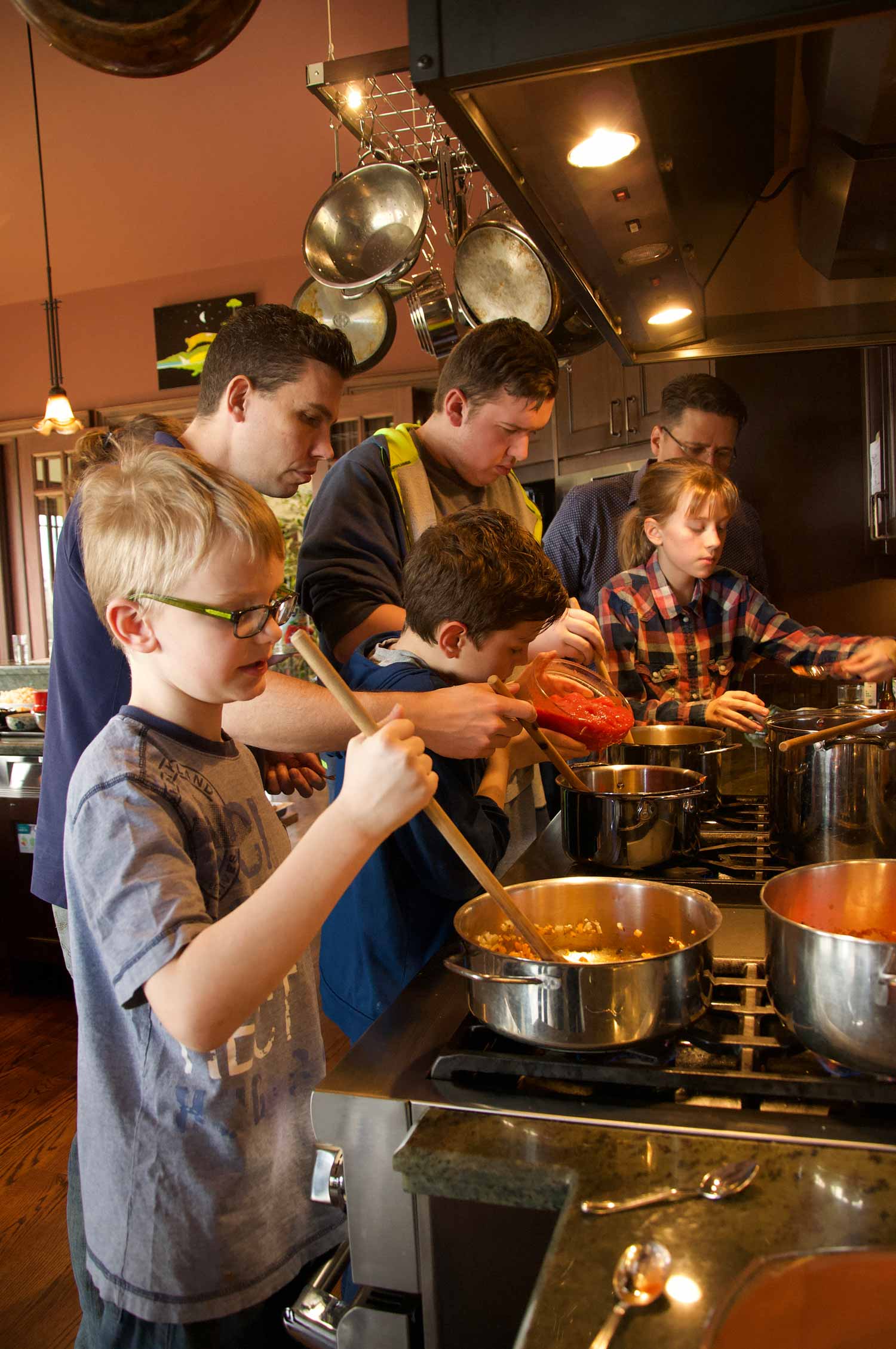 Students gathered around the stove at a past Tree House Kitchen cooking class.