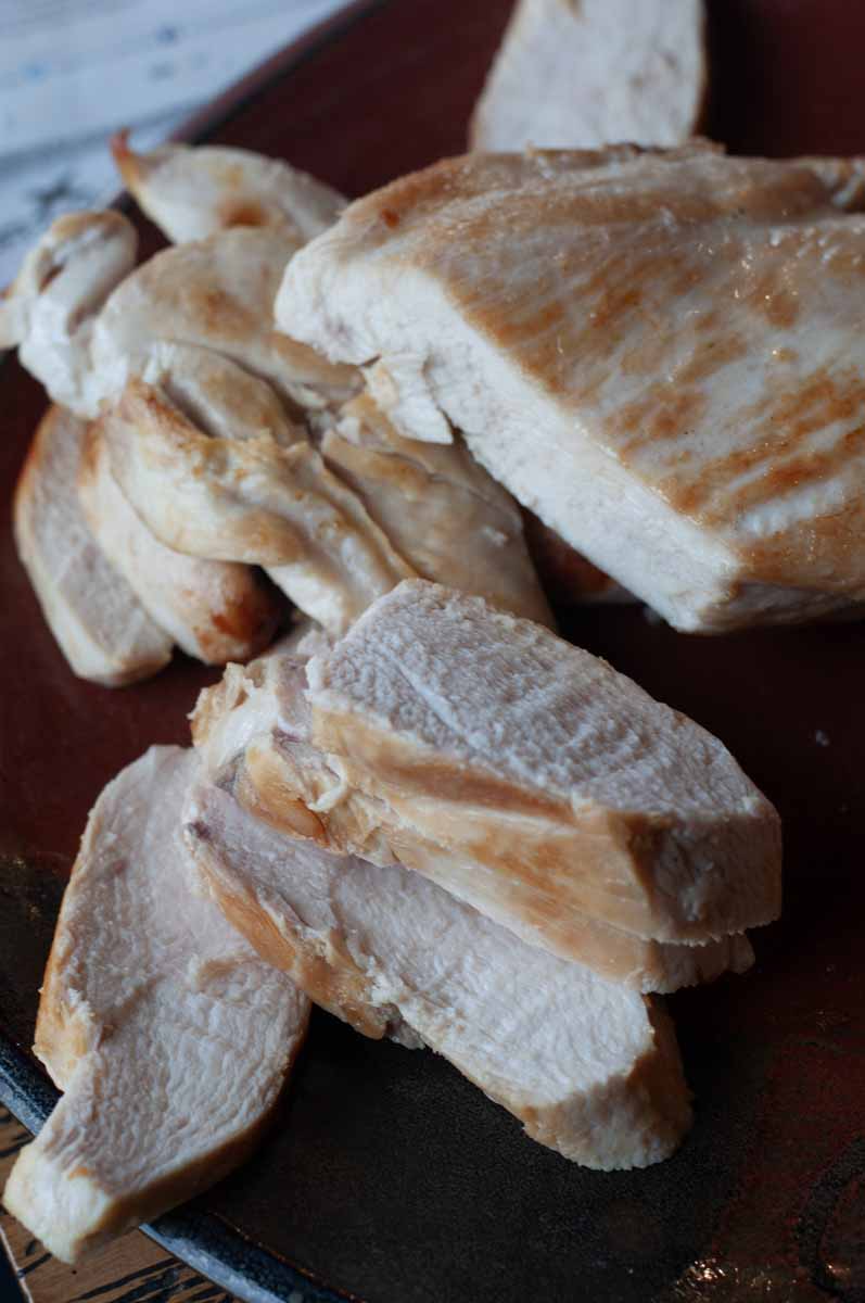 Seared chicken breast, with slices revealing no pinkness and all juiciness.